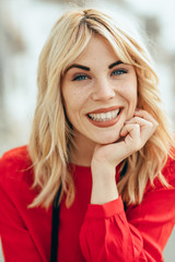 Fototapeta premium Smiling blonde girl with red shirt enjoying life outdoors.