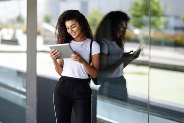 Obraz premium Happy young Arab woman using digital tablet in business background.