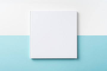 Top view of white hardcover notebook on blue