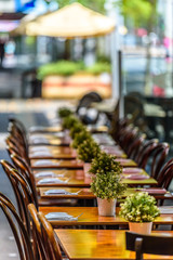 A row of chairs and tables at a outdoor cafe on Lygon Street, Carlton, Melbourne, Australia