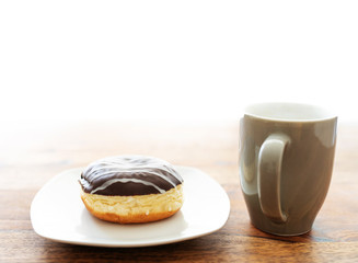 jelly doughnut and coffee cup on wooden table
