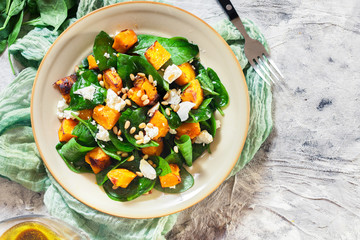 Roasted pumpkin salad with spinach and nuts