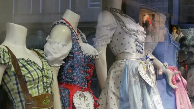 Beautiful various women's national Bavarian costumes dirndl on shop window