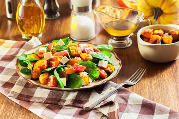 Roasted pumpkin salad with spinach, tomatoes and nuts