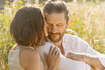 girl hugs a man with his eyes closed