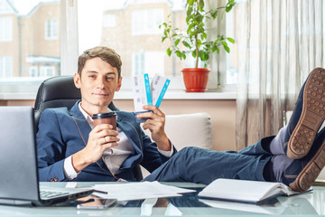 The young man is holding the won tickets. The joy of waiting for the journey. Concept of the office on vacation