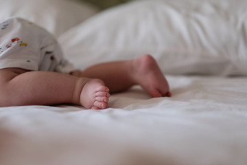 feet of a small child lying on the bed