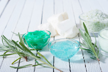 cosmetic cream product samples and raw shea butter, bath salt on white wood table background