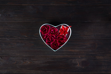Valentines background with red hearts shaped and bouquet rose in gift box on dark wooden background, flat lay copy space