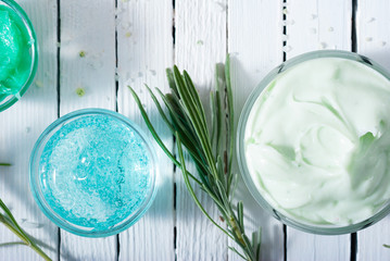 cosmetic cream product samples and lavender leaves on white wooden table background