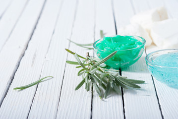 cosmetic cream product samples and lavender leaves on white wooden table background