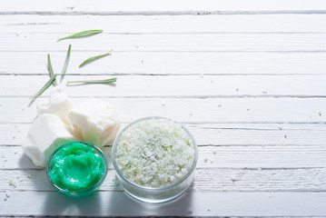 cosmetic cream product samples and raw shea butter, bath salt on white wood table background