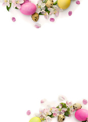 Easter decoration. Frame of pink flowers apple tree, colored easter eggs and quail eggs on white background with space for text. Top view, flat lay