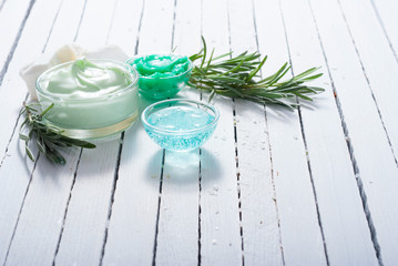 cosmetic cream product samples and lavender leaves on white wooden table background