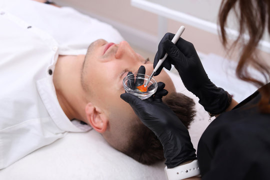 Cleaning the face of a man in a beauty salon.