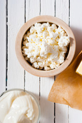 cottage cheese at wooden bowl, white wood table