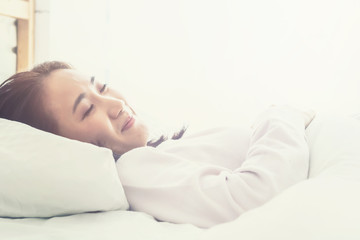 Asian woman sleep on  white pillow on bed in bedroom in holiday.happy relax time