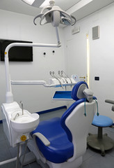 dental clinic with chair and large lamp to illuminate the work o