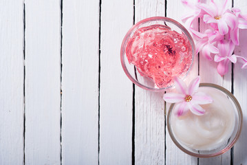 beauty products with hyacinth flowers on white wood