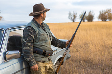 Hunter with a hat and a gun in search of prey in the steppe	