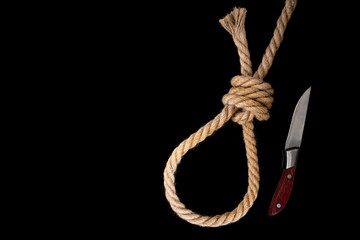 Rope and knife on black background. Suicide. Running knot. 