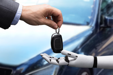 Businessperson Giving Car Key To Robot