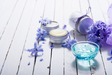skin care product samples and purple hyacinth flowers on white wooden