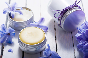 skin care product samples and purple hyacinth flowers on white wooden