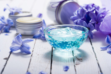 skin care product samples and purple hyacinth flowers on white wooden