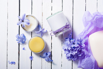 skin care product samples and purple hyacinth flowers on white wooden