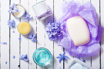 skin care product samples and purple hyacinth flowers on white wooden