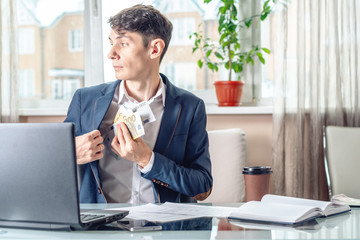 Fototapeta premium Businessman official sitting in the office hides a bribe unnoticed in his pocket. Corruption and bribery