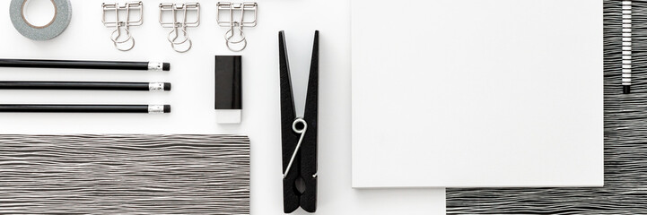 Flat lay white skretch book mockup with black office supplies on white  desk. Top view mockup. Panoramic blog template. Black and white geometrical concept..