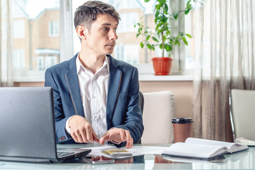 Fototapeta premium Businessman official sitting in the office hides a bribe unnoticed in his pocket. Corruption and bribery