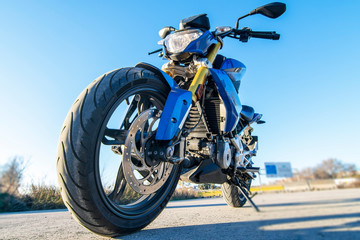 Obraz na płótnie Canvas Blue motorcycle on the road contrapicado view.