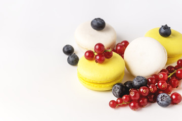 French Colorful Macarons White and Yellow Macarons on Blue Background with Fresh Red Currant Copy Space Horizontal French Dessert