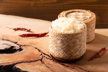 Asian Thai food Glutinous or sticky rice in bamboo wicker on wooden background with copy space