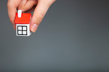 Man holds small house in hand