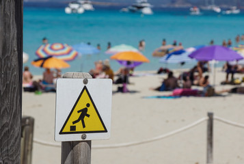 Drop warning sign , falling of the edge yellow triangle warning sign on the beach