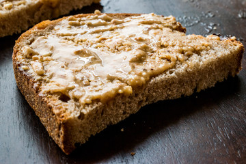 Creamy Peanut Butter with Bread on Wooden Board.