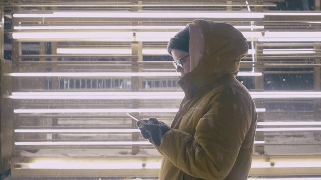 Woman use of smart phone in the winter time at night