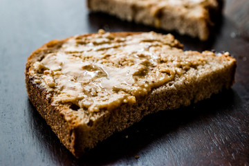 Creamy Peanut Butter with Bread on Wooden Board.