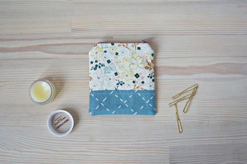 Handmade mini pouch, golden hairpins and lip balm on the wooden desk