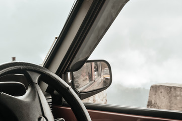 Side rear-view mirror on a car on a countryside road.Selective focus