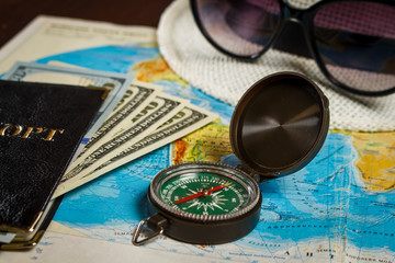 Compass on a map with dollars and a hat