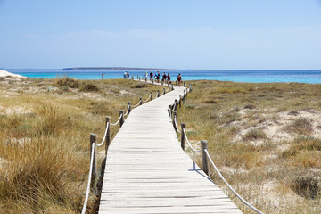 Wooden boardwalk and turquoise water at the Illetes beach in Formentera. Balearic Islands. Spain