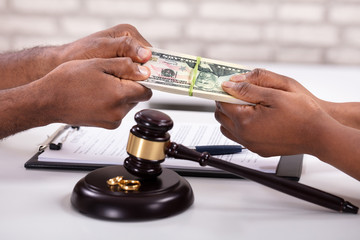 Close-up Of Husband And Wife Dividing Money