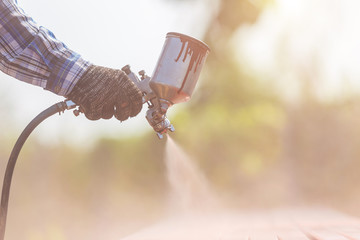 Worker spraying paint to steel pipe to prevent the rust on the surface