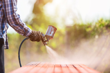 Worker spraying paint to steel pipe to prevent the rust on the surface