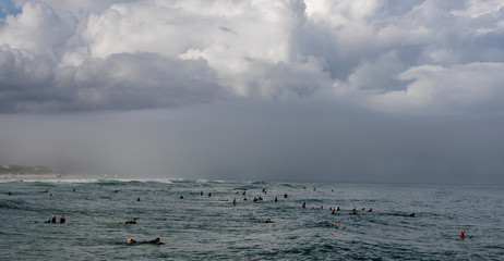 clouds over sea surfers 